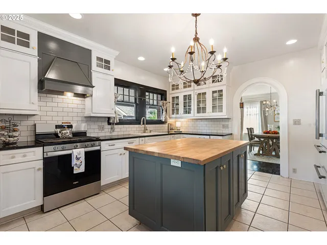 a kitchen with stainless steel appliances granite countertop a stove a sink dishwasher and cabinets with wooden floor