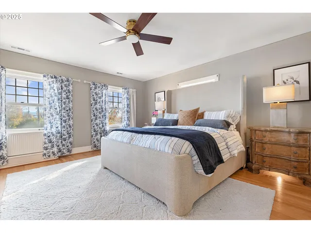 a bedroom with a large bed and a chandelier fan