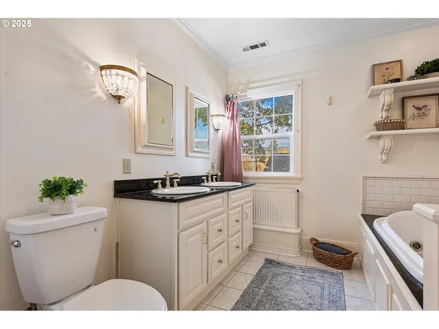 a bathroom with a sink vanity granite toilet and a mirror