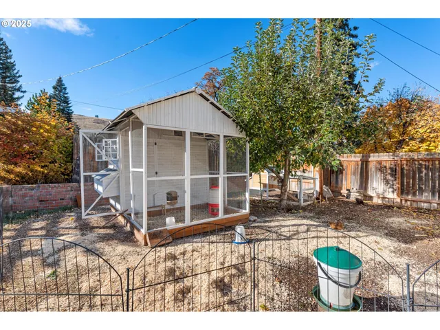 a view of a small house with yard and sitting area