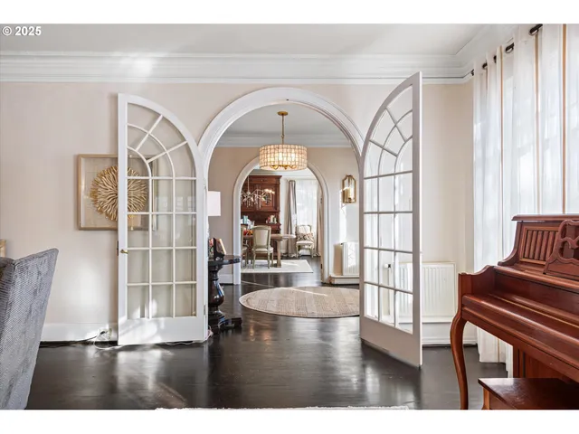 a living room with a large window and wooden floor
