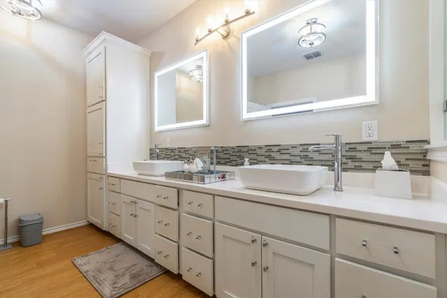 a spacious en suite bathroom with a granite countertop tub and a sink
