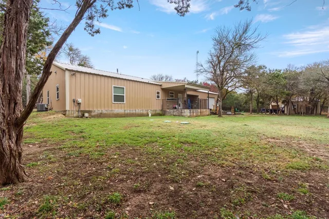 a view of a house with backyard and tree