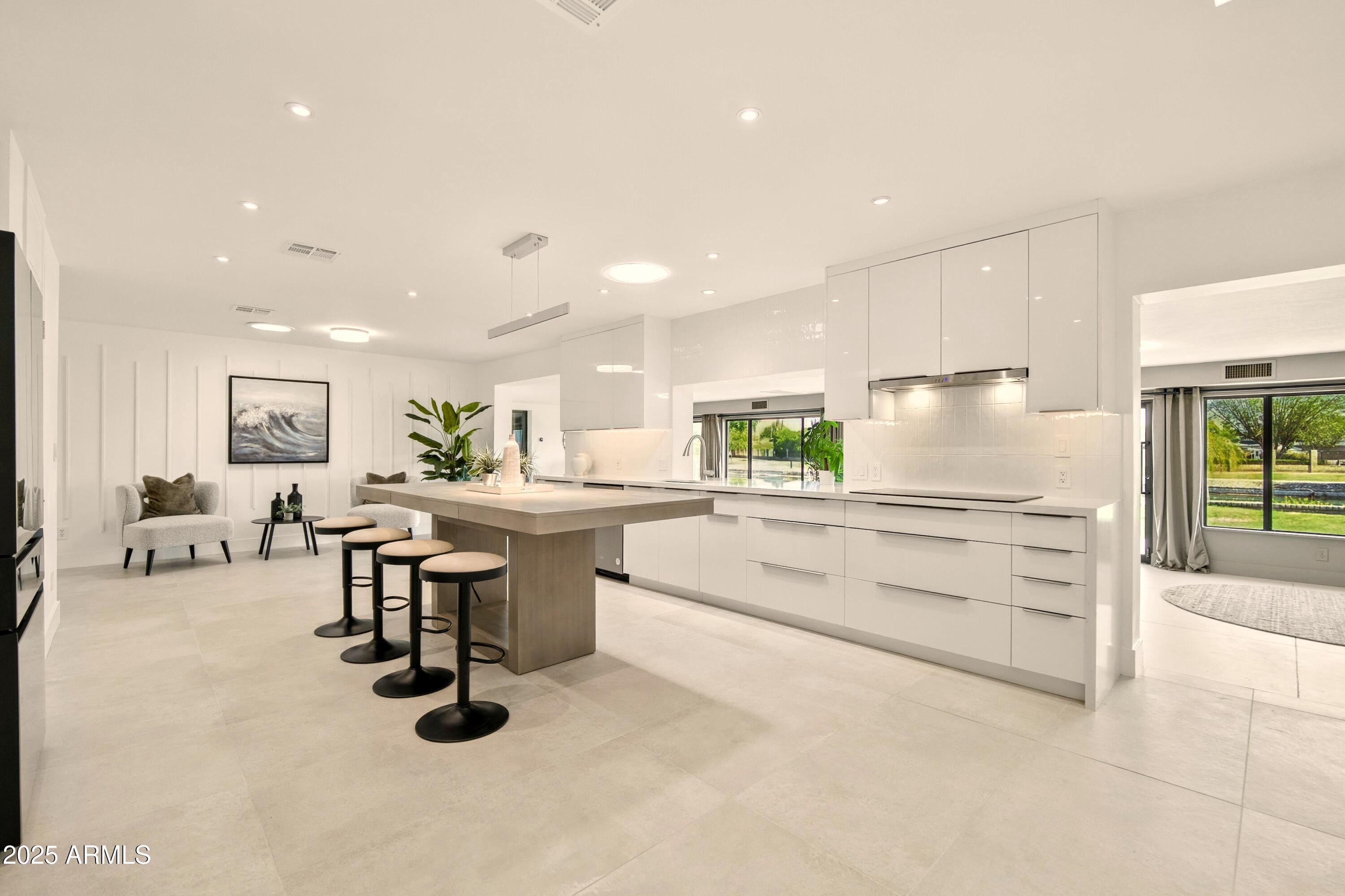 2425 West Impala Circle Mesa, AZ 85202 - Photo 15 of 55 a kitchen with kitchen island white cabinets and chairs