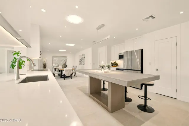 a kitchen with a sink and chairs