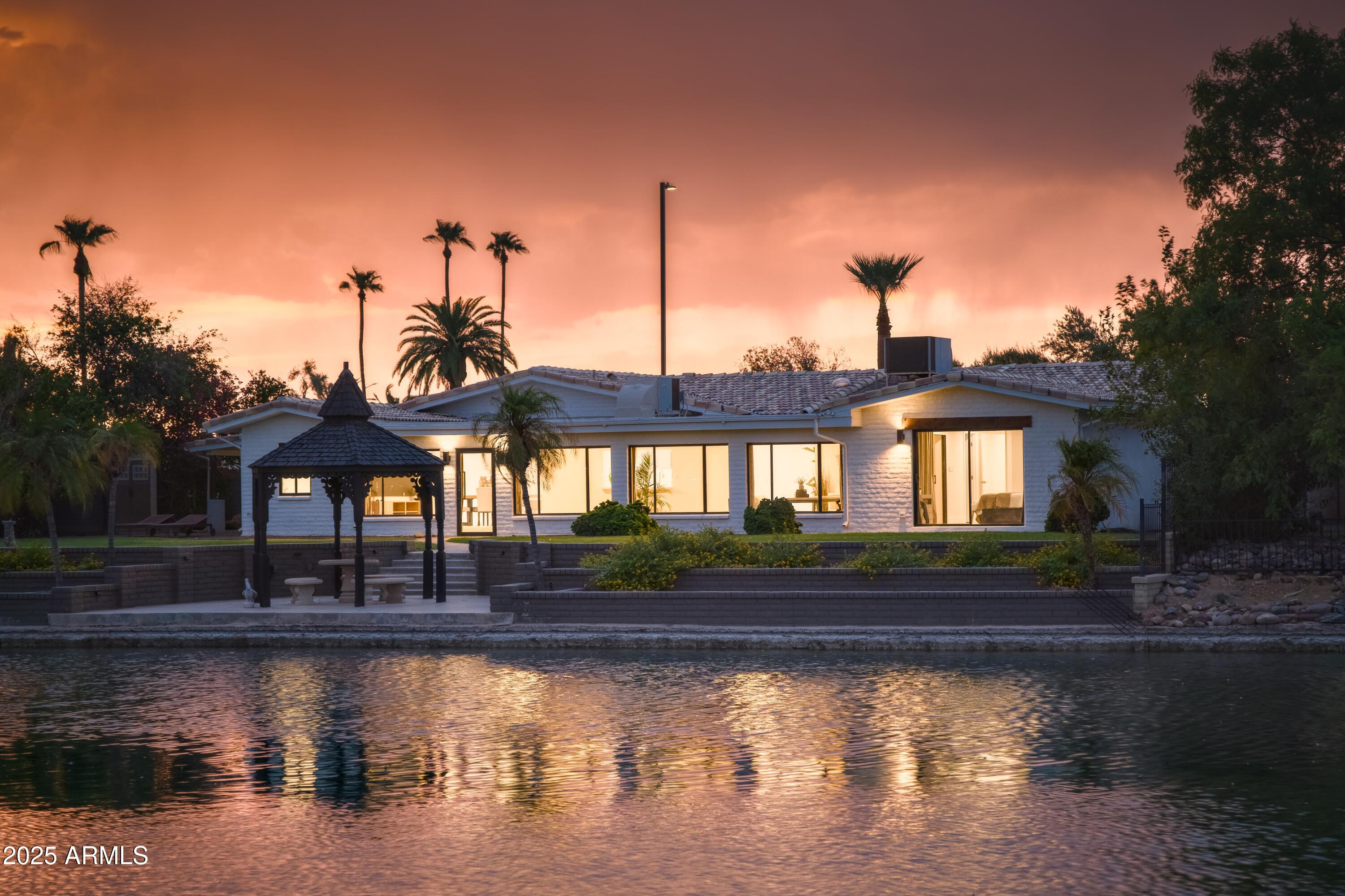 2425 West Impala Circle Mesa, AZ 85202 - Photo 46 of 55 a view of a lake with a house in the background