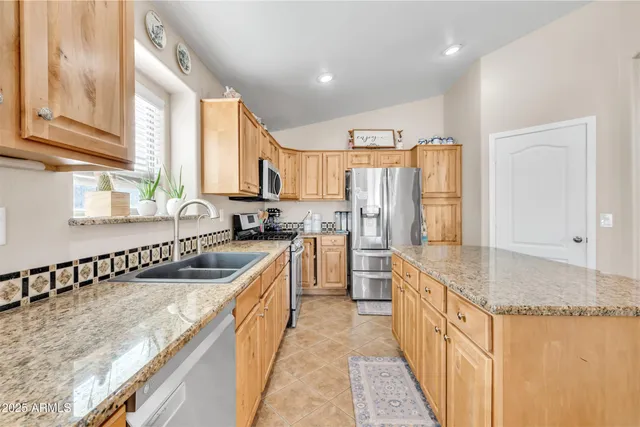 a kitchen with stainless steel appliances granite countertop a stove a sink and a microwave