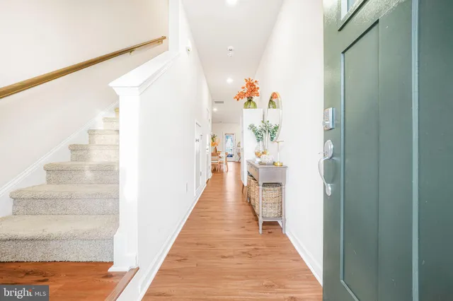 a view of a hallway with wooden floor and stairs
