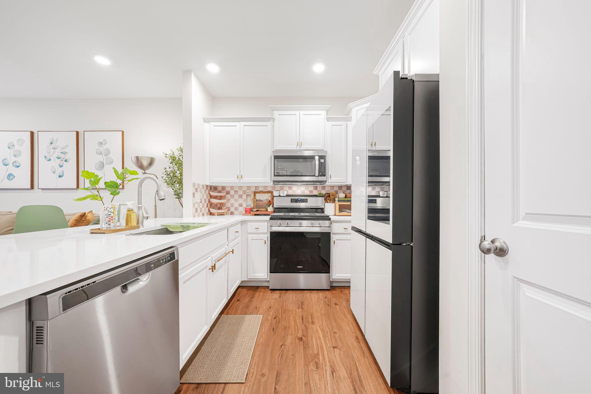 69 Peregrine Way Burlington, NJ 08016 - Photo 5 of 28 a kitchen with a refrigerator a sink and a stove top oven