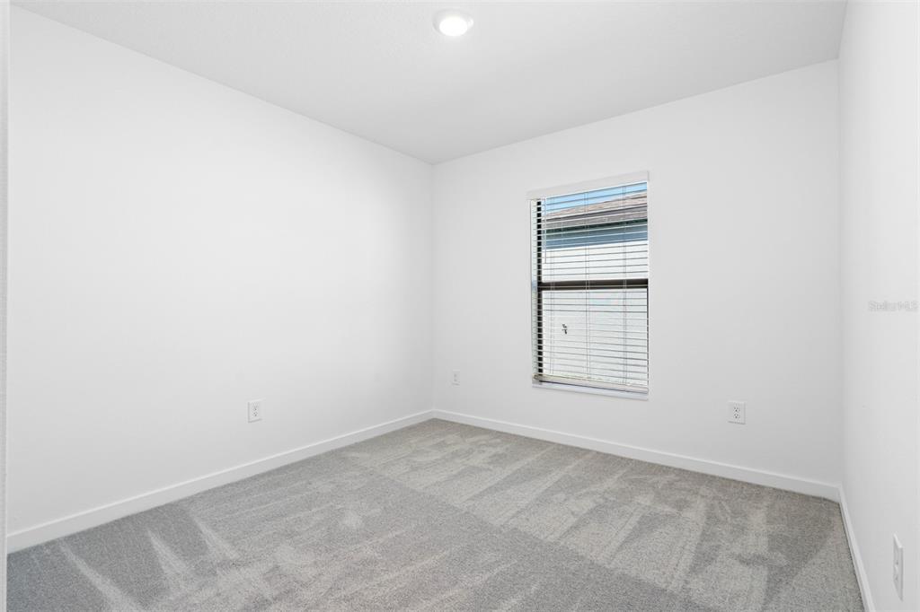 14049 Candia Street Spring Hill, FL 34609 - Photo 7 of 8 an empty room with windows