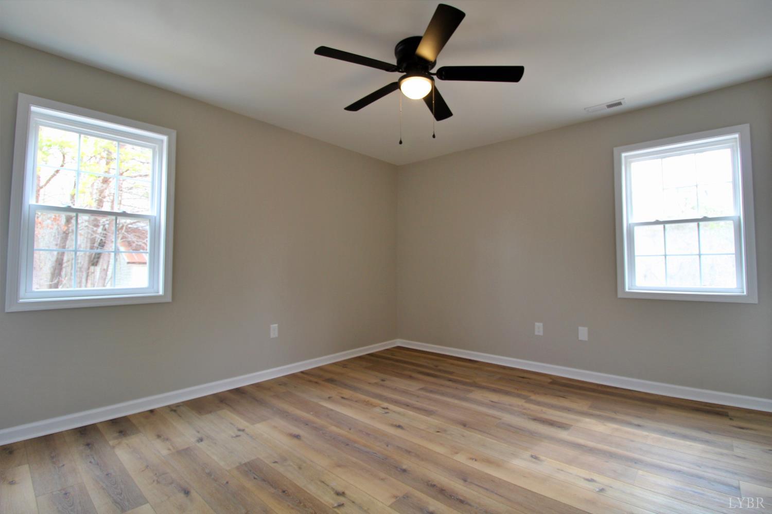 1740 Watt Abbitt Road Appomattox, VA 24522 - Photo 16 of 29 a view of empty room with wooden floor and fan