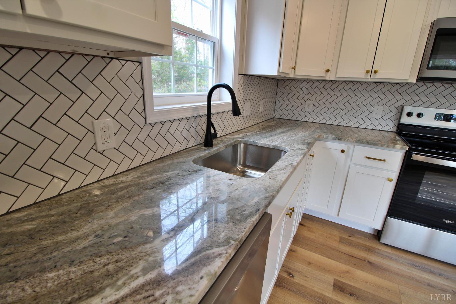 1740 Watt Abbitt Road Appomattox, VA 24522 - Photo 20 of 29 a kitchen with granite countertop a sink and a stove top oven