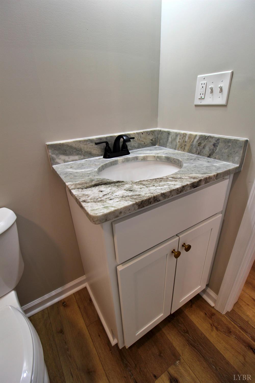 1740 Watt Abbitt Road Appomattox, VA 24522 - Photo 4 of 29 a bathroom with a granite countertop sink and toilet