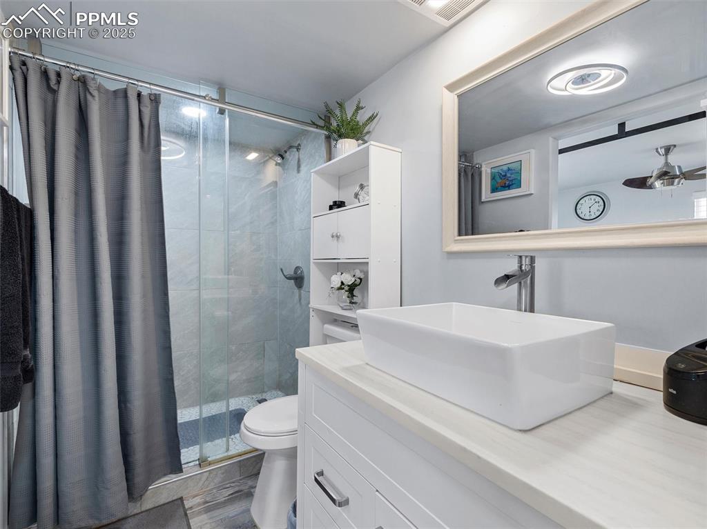 32092 Torrence Road Yoder, CO 80864 - Photo 19 of 44 a bathroom with a sink a toilet a mirror and shower