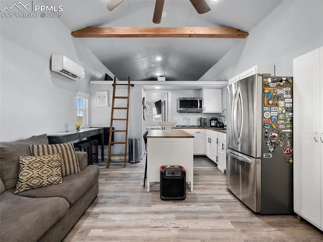 a kitchen with stainless steel appliances kitchen island granite countertop a refrigerator and a stove top oven