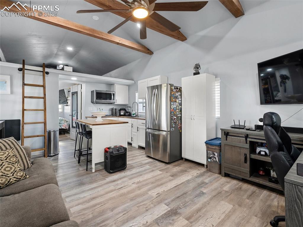 32092 Torrence Road Yoder, CO 80864 - Photo 7 of 44 a living room with furniture a flat screen tv and kitchen view