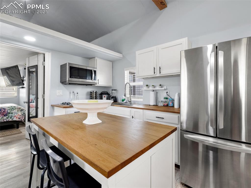 32092 Torrence Road Yoder, CO 80864 - Photo 9 of 44 a kitchen with kitchen island a stove a sink a refrigerator and a dining table