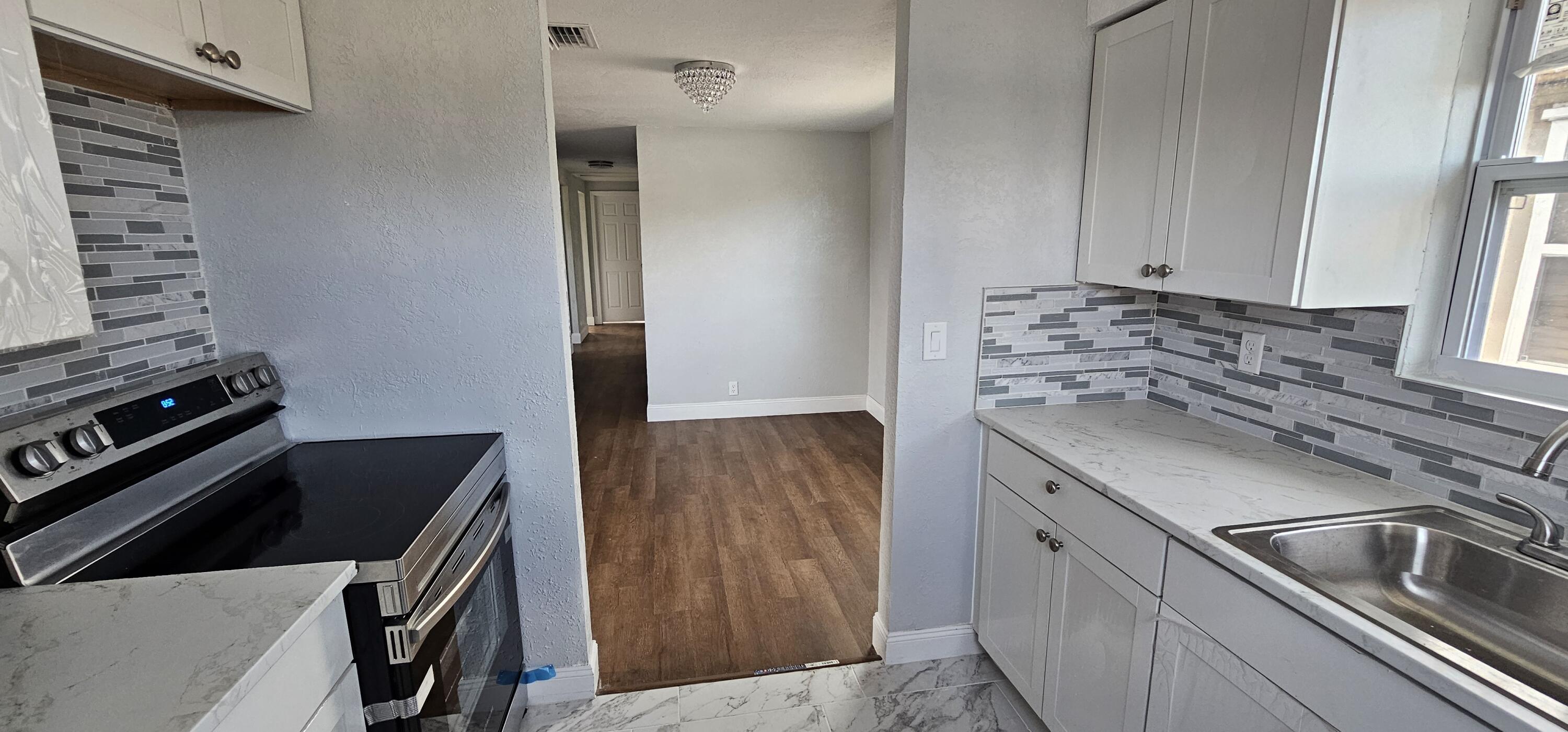 540 Southwest 9th Street Belle Glade, FL 33430 - Photo 11 of 28 a kitchen that has a sink and a stove