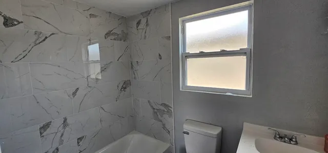 a bathroom with a toilet and a shower