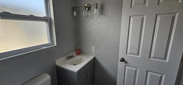 a bathroom with a sink toilet and mirror
