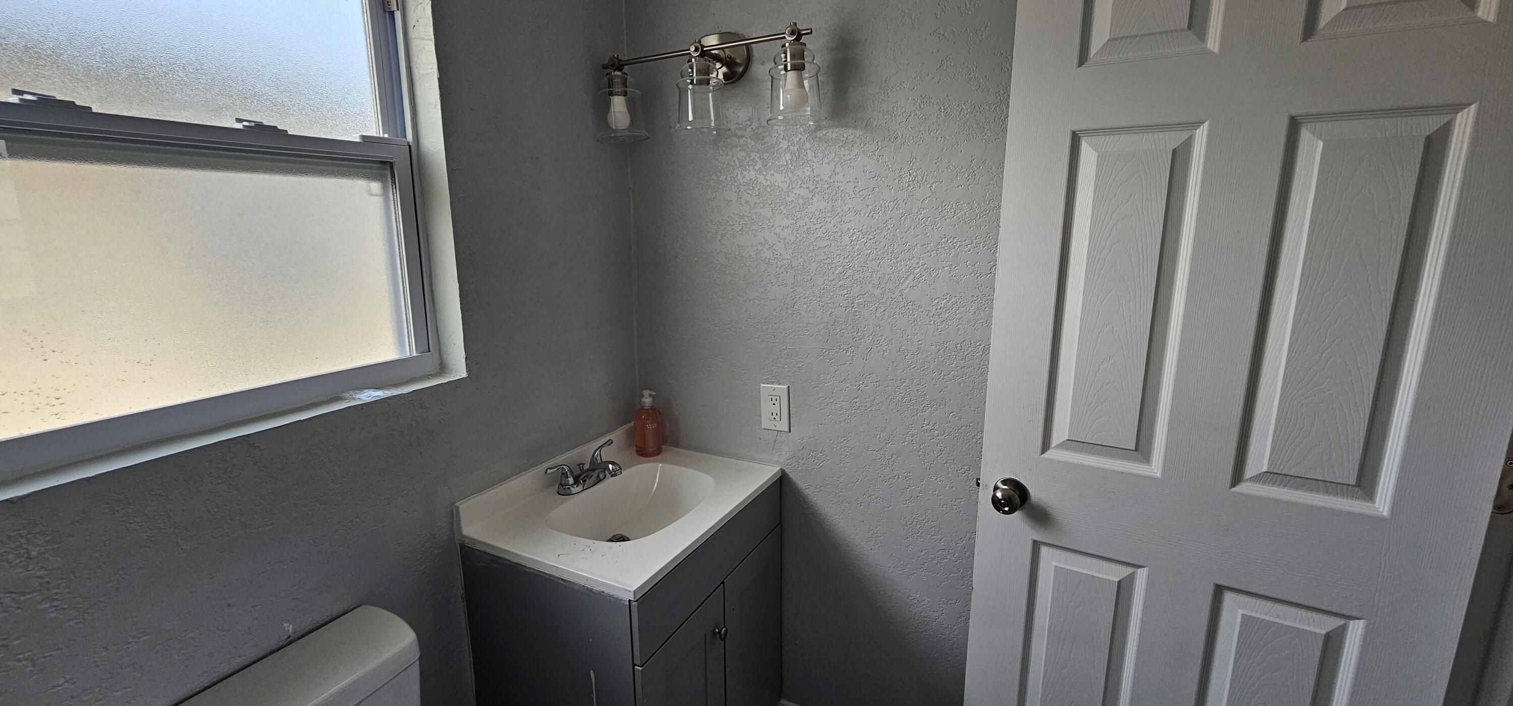 540 Southwest 9th Street Belle Glade, FL 33430 - Photo 15 of 28 a bathroom with a sink toilet and mirror