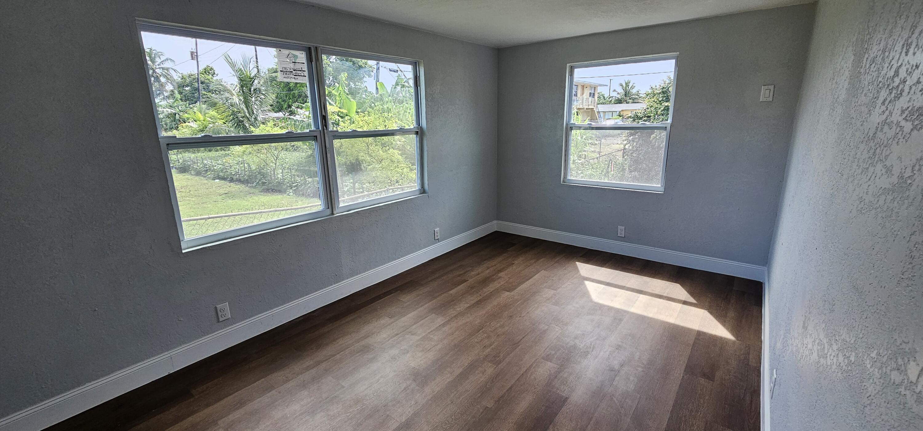 540 Southwest 9th Street Belle Glade, FL 33430 - Photo 16 of 28 a view of an empty room with wooden floor and a window