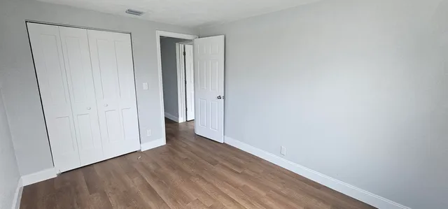 a view of an empty room with wooden floor