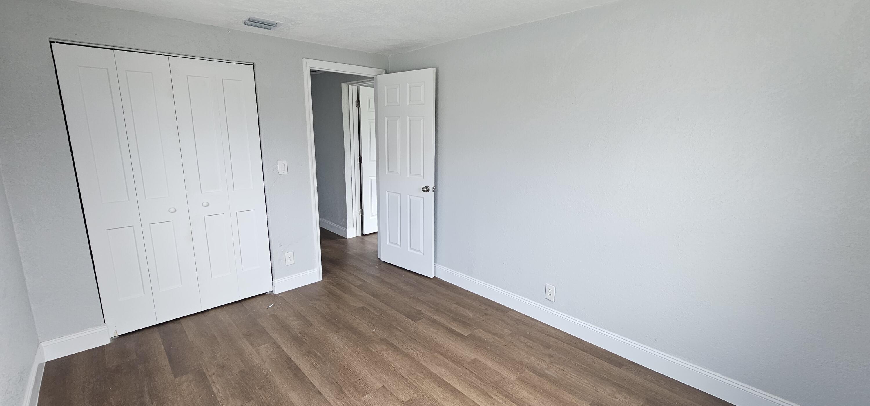 540 Southwest 9th Street Belle Glade, FL 33430 - Photo 19 of 28 a view of an empty room with wooden floor