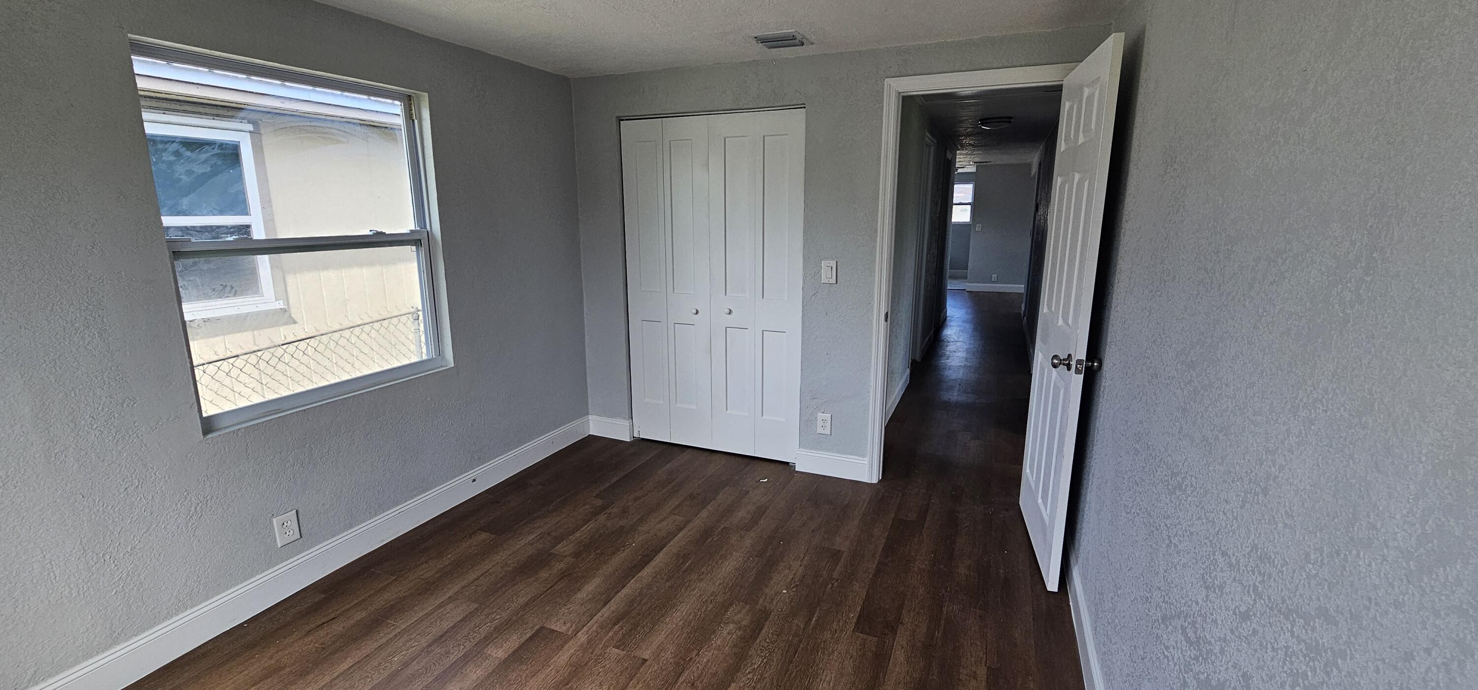 540 Southwest 9th Street Belle Glade, FL 33430 - Photo 20 of 28 an empty room with wooden floor and windows