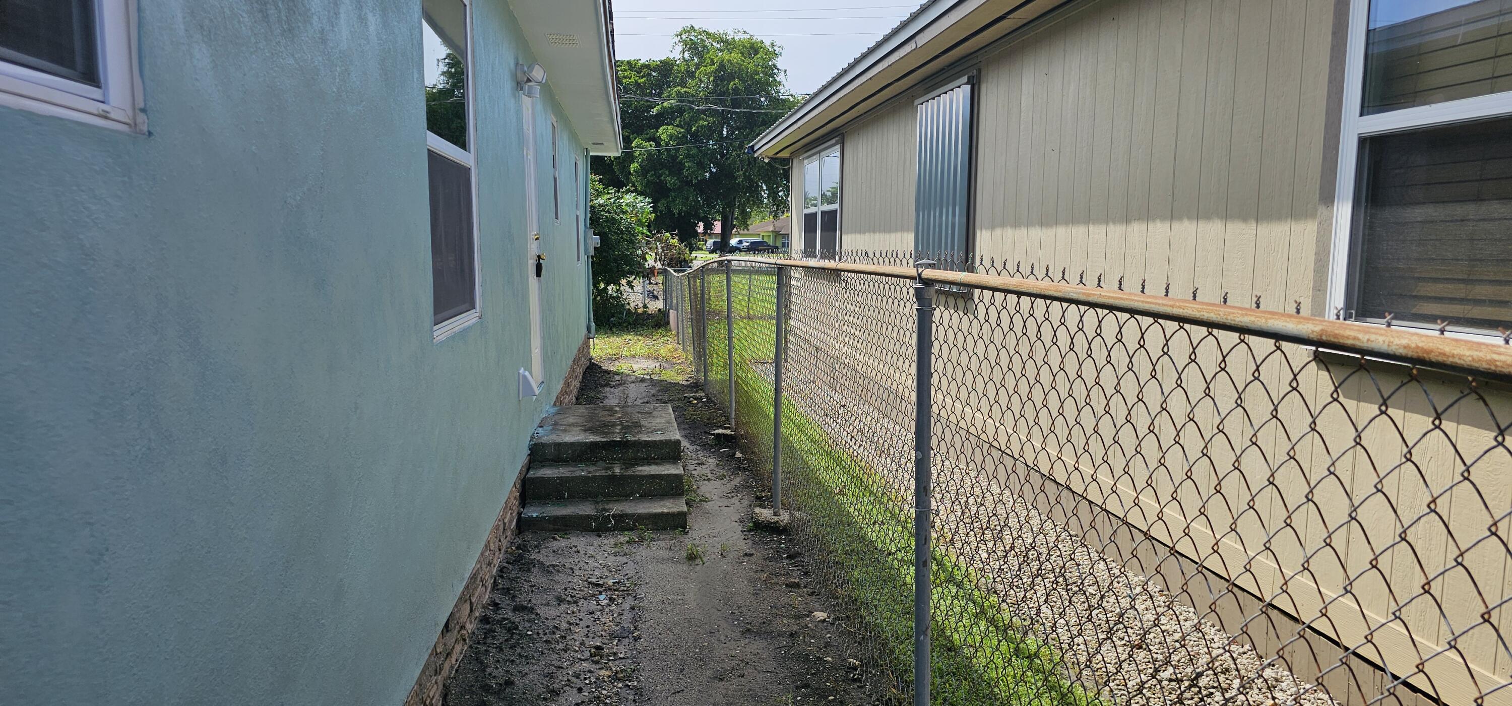 540 Southwest 9th Street Belle Glade, FL 33430 - Photo 22 of 28 a view of a pathway of a house with wooden fence