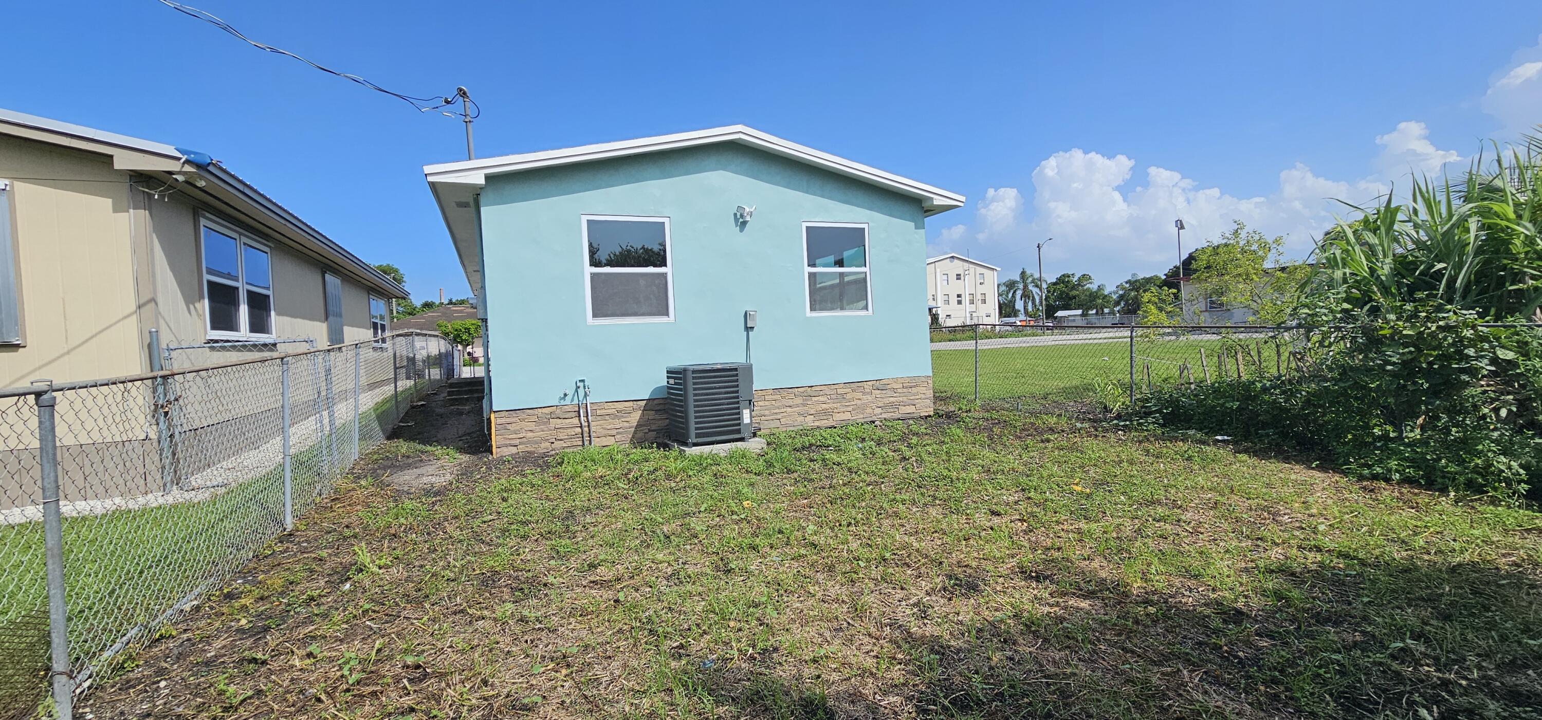 540 Southwest 9th Street Belle Glade, FL 33430 - Photo 24 of 28 a front view of a house with garden