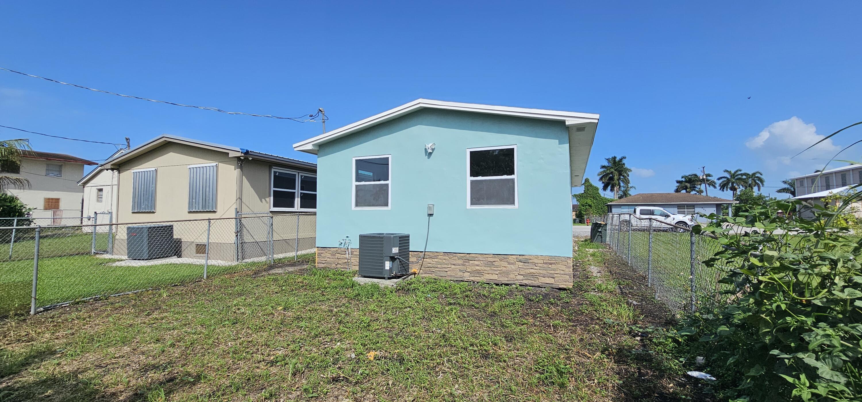 540 Southwest 9th Street Belle Glade, FL 33430 - Photo 25 of 28 a front view of a house with garden