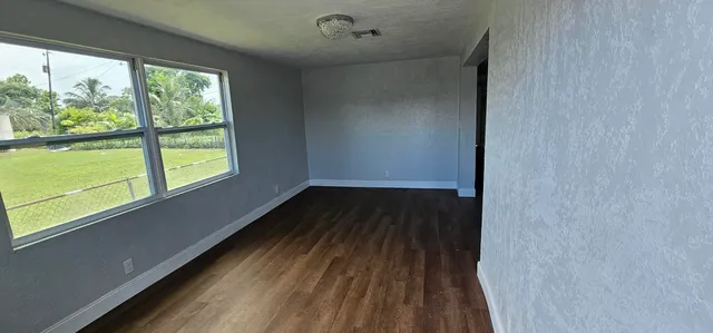 a view of a room with wooden floor and windows