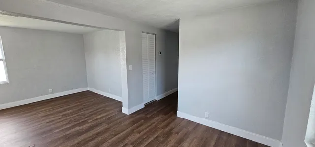 a view of an empty room with wooden floor