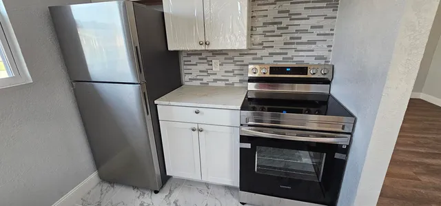 a kitchen with a stove and a refrigerator