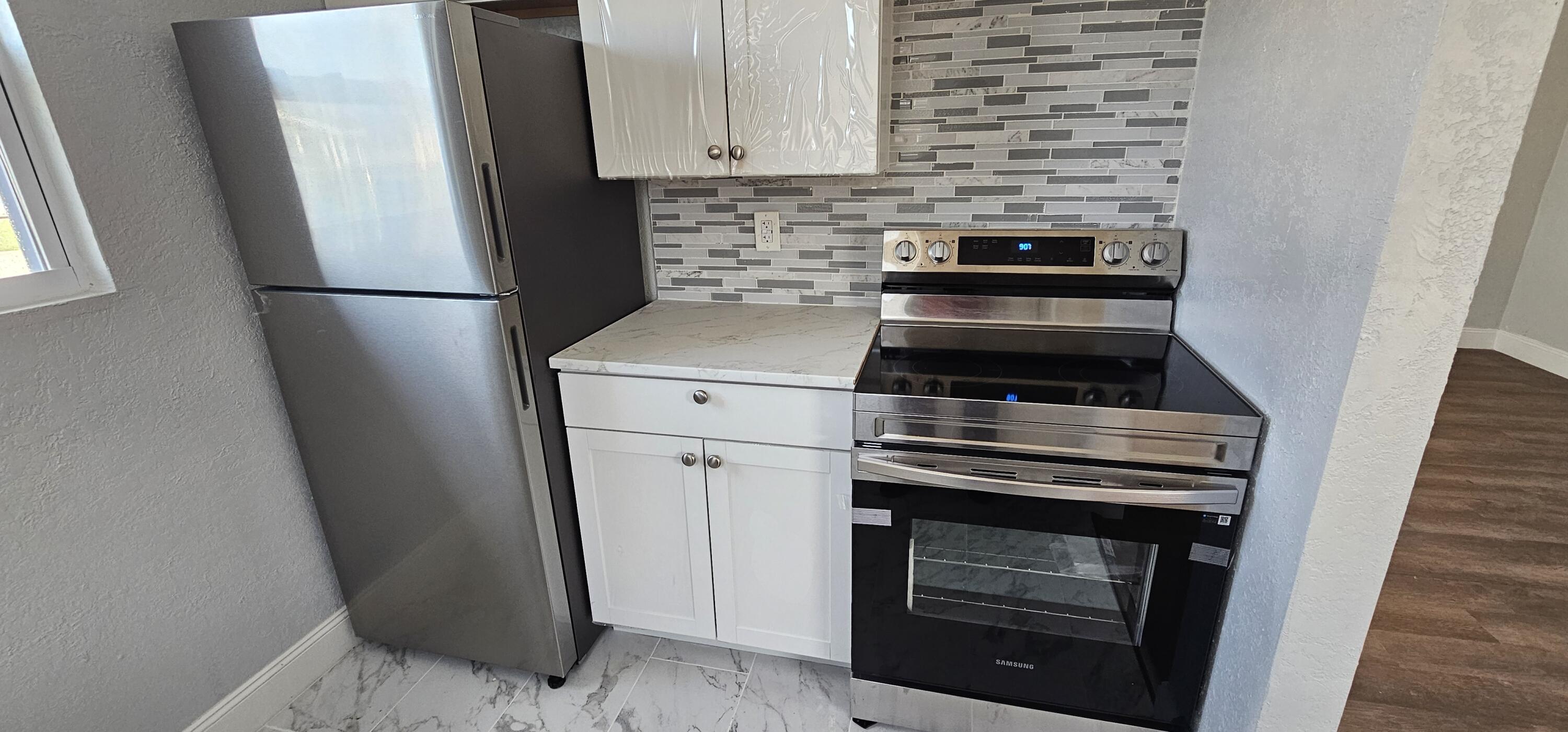 540 Southwest 9th Street Belle Glade, FL 33430 - Photo 9 of 28 a kitchen with a stove and a refrigerator