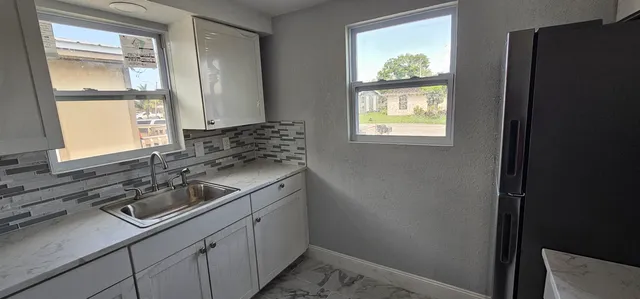 a kitchen with a sink window and cabinets