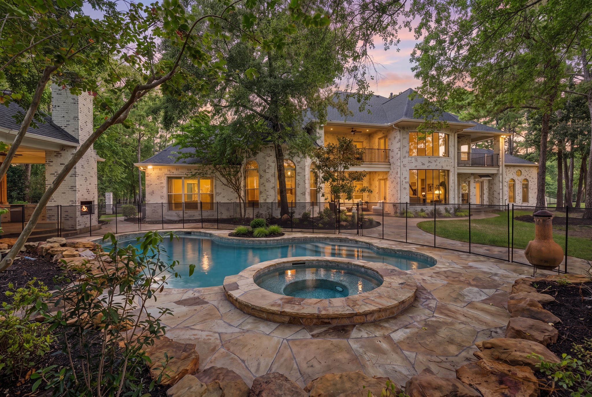 31 Hollymead Drive Spring, TX 77381 - Photo 2 of 50 The wooded backyard includes a beautiful pool/spa, full outdoor kitchen with a grill, beverage refrigerator, mounted TV and fireplace plus child safety fencing which is removeable, A wonderful serene outdoor retreat.