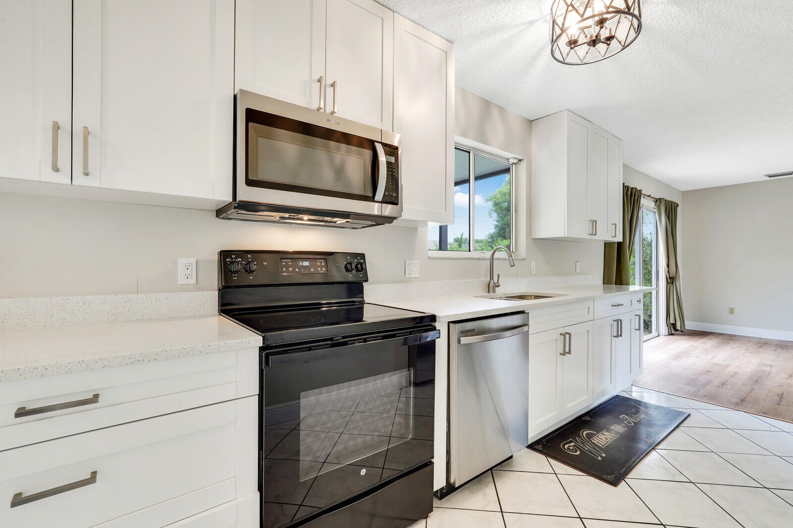 2334 Southeast Merrill Road Port St. Lucie, FL 34952 - Photo 12 of 27 a kitchen with white cabinets and stainless steel appliances