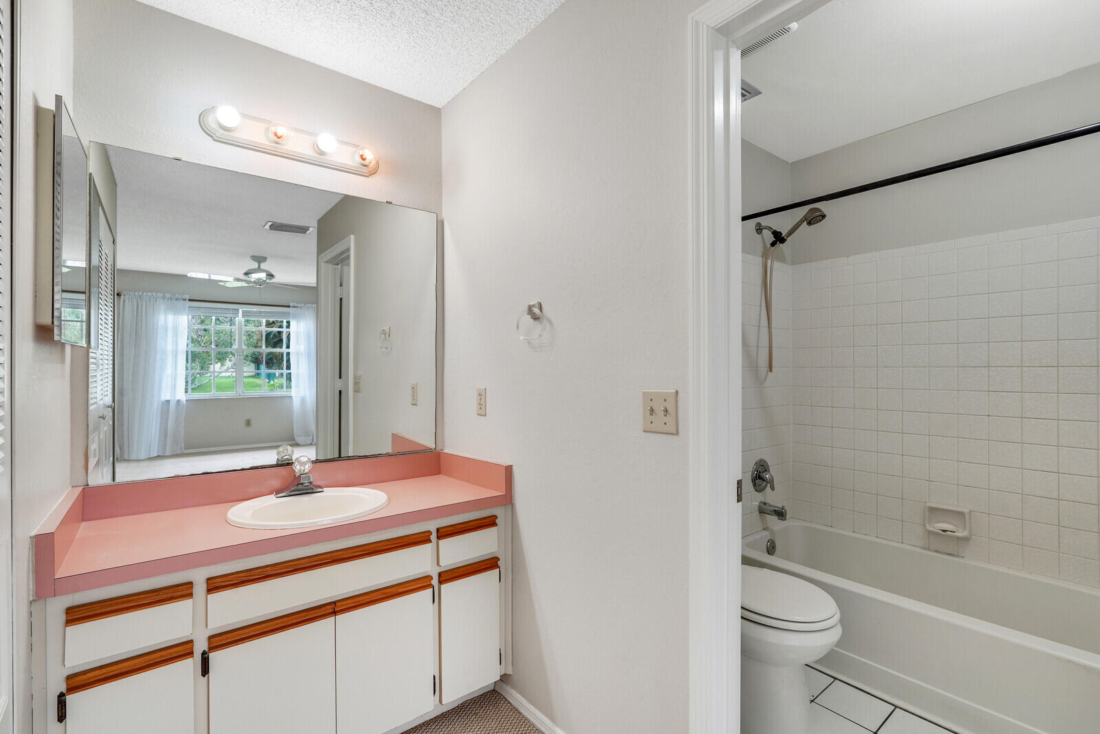 2334 Southeast Merrill Road Port St. Lucie, FL 34952 - Photo 15 of 27 a bathroom with a sink a toilet a mirror and shower
