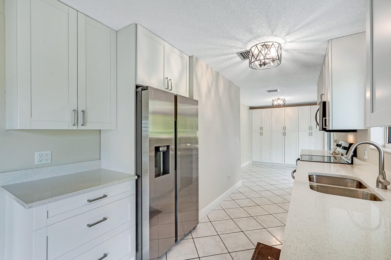 2334 Southeast Merrill Road Port St. Lucie, FL 34952 - Photo 9 of 27 a kitchen with a sink and a refrigerator