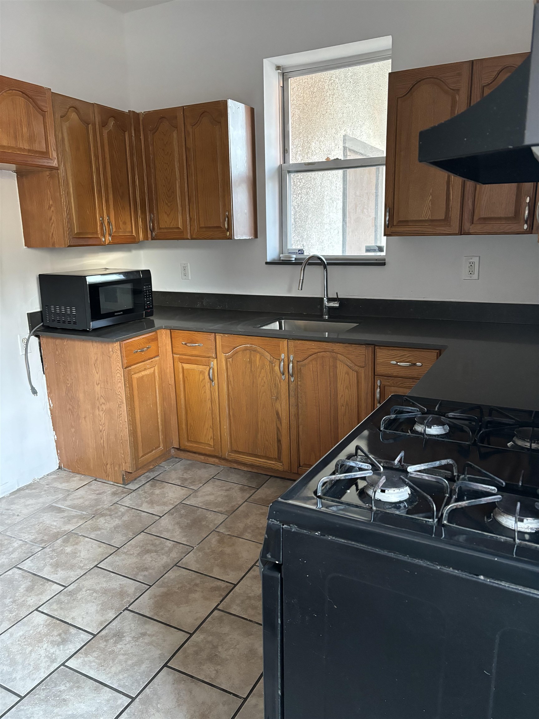 178 Orient Street, Unit 2 Bayonne, NJ 07002 - Photo 2 of 9 a kitchen with granite countertop a sink a stove and cabinets