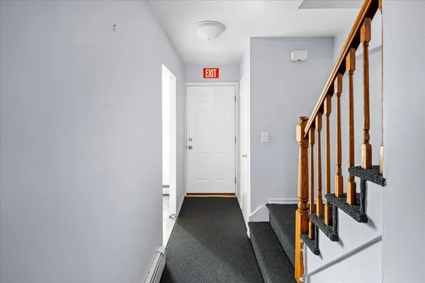 a view of a hallway with wooden floor and staircase