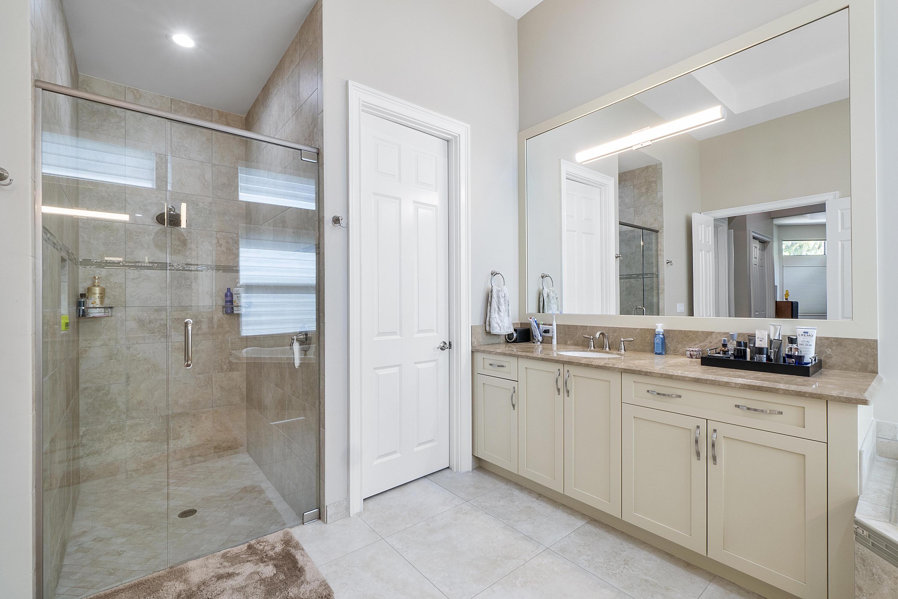 16897 Pierre Circle Delray Beach, FL 33446 - Photo 14 of 37 a bathroom with a shower sink and mirror
