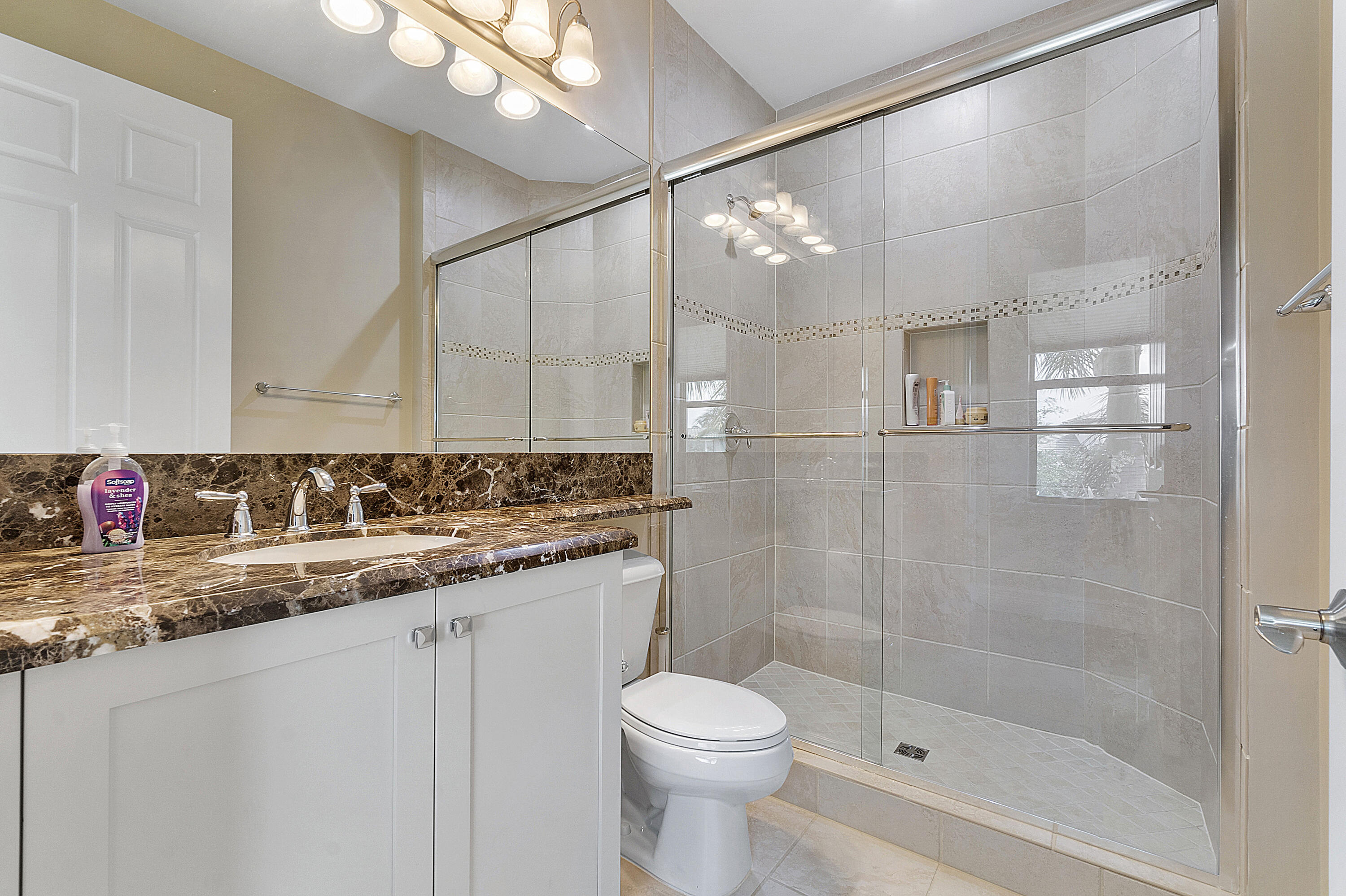 16897 Pierre Circle Delray Beach, FL 33446 - Photo 17 of 37 a bathroom with a granite countertop sink a toilet and shower