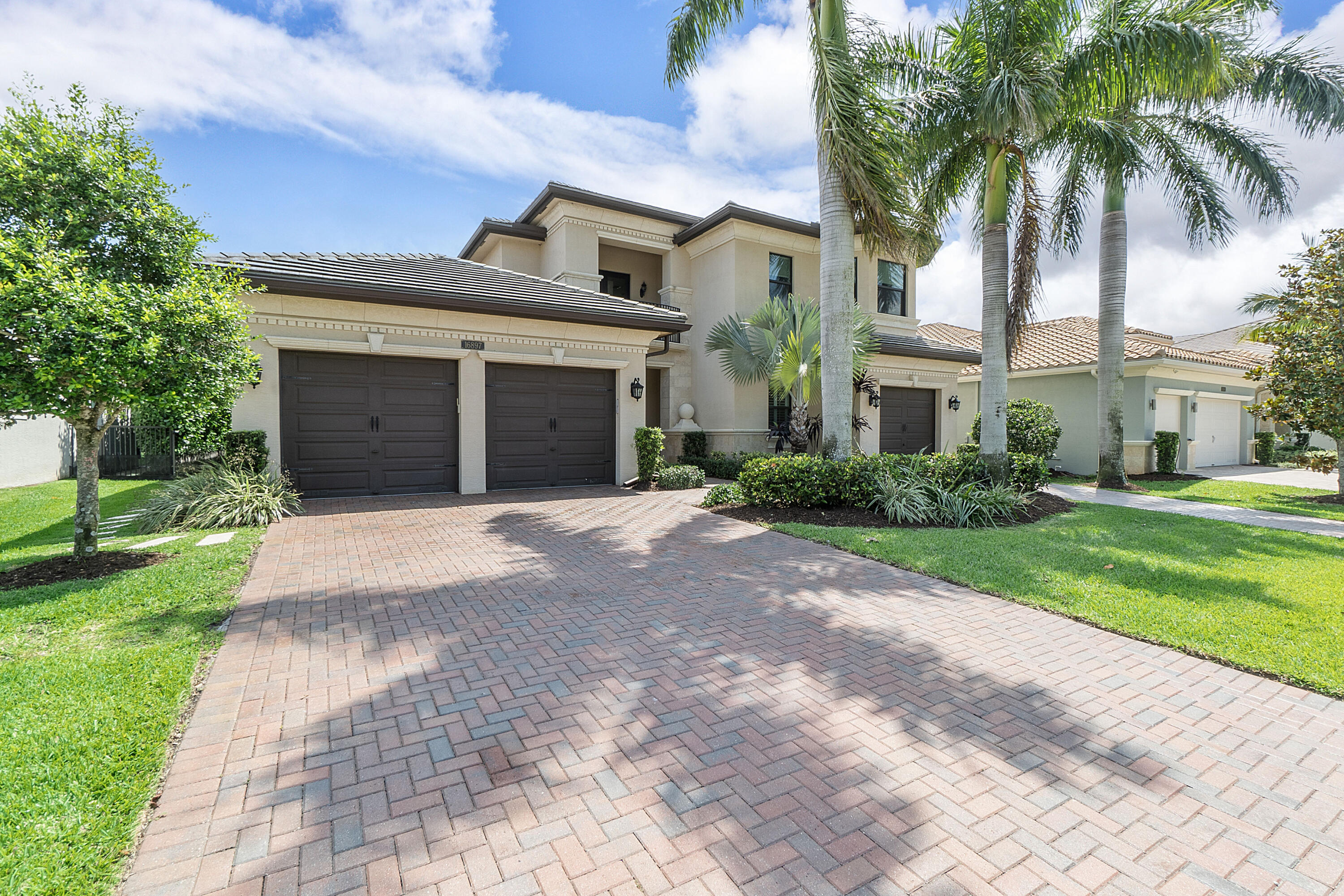 16897 Pierre Circle Delray Beach, FL 33446 - Photo 2 of 37 a front view of a house with a yard and palm trees