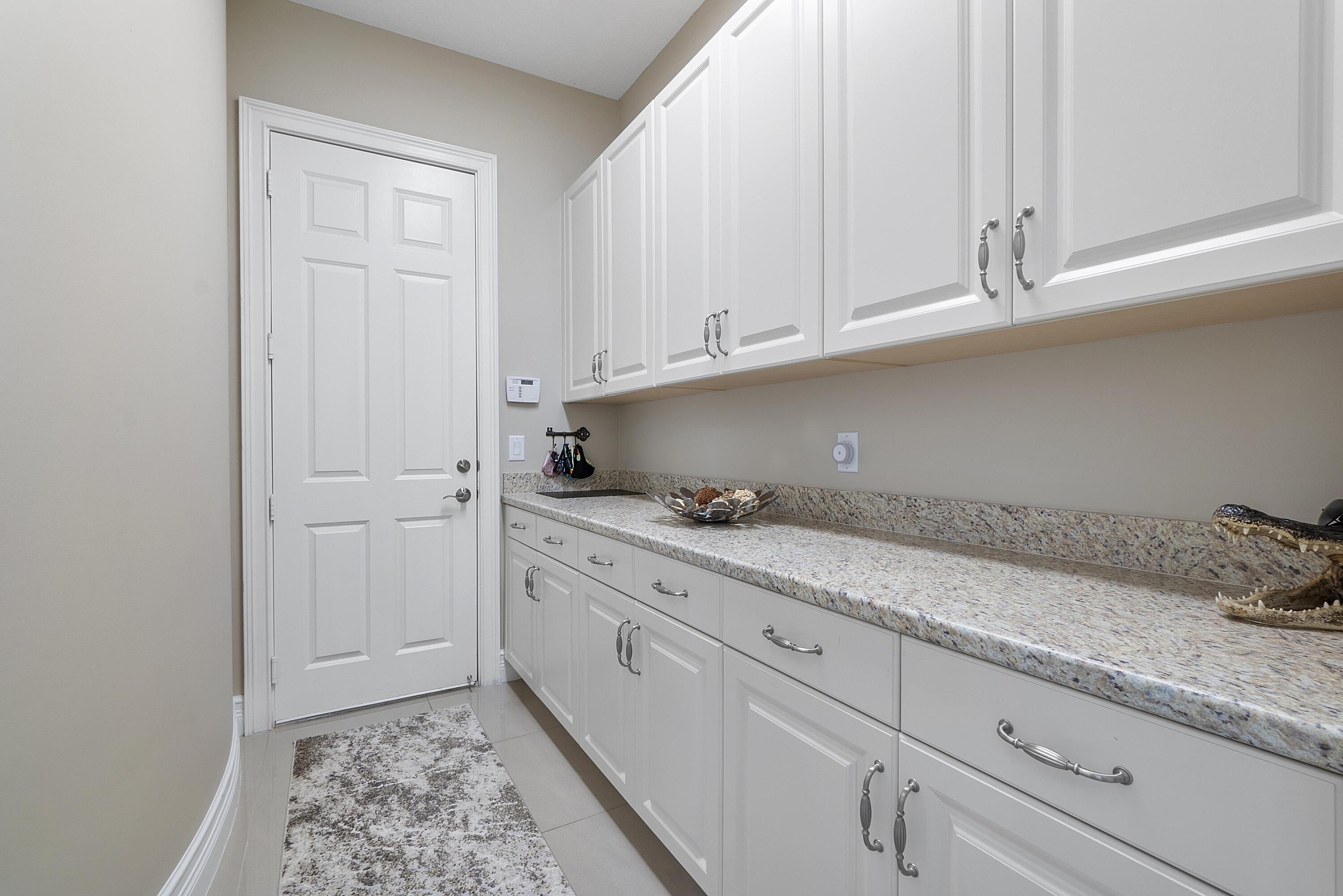 16897 Pierre Circle Delray Beach, FL 33446 - Photo 25 of 37 a kitchen with granite countertop white cabinets and sink