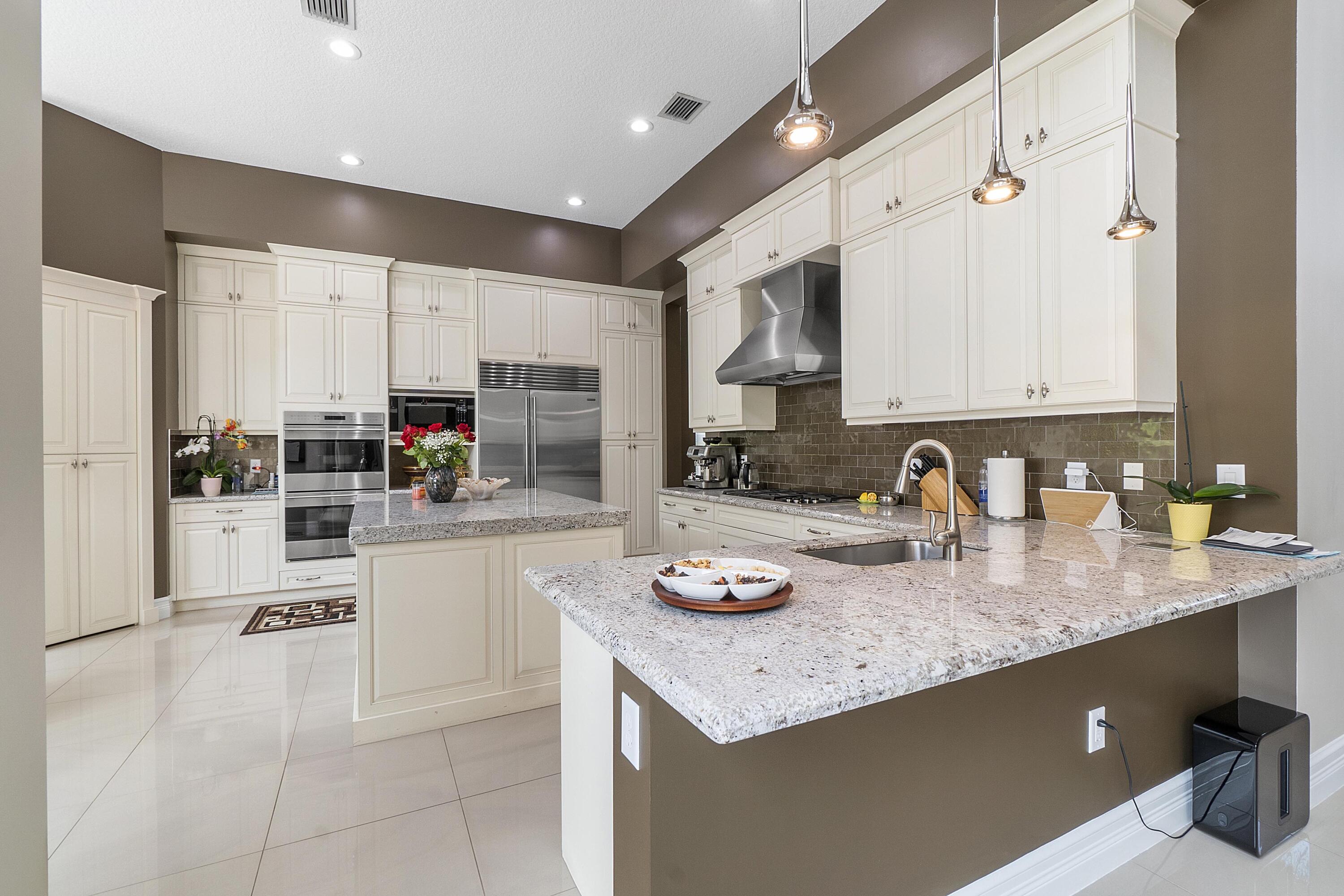 16897 Pierre Circle Delray Beach, FL 33446 - Photo 10 of 37 a kitchen with granite countertop a sink a stove and cabinets