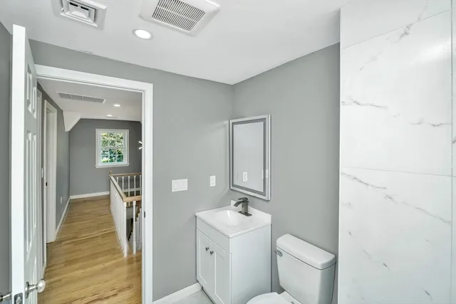 a bathroom with a toilet sink and mirror