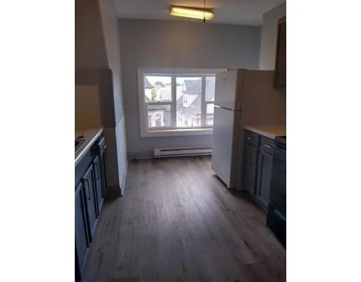 a view of a livingroom with wooden floor and a window